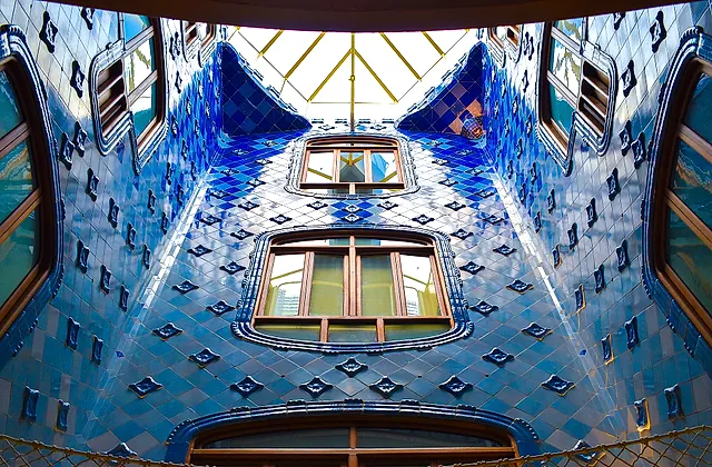 Il lucernario centrale di Casa Batlló, con le pareti rivestite di piastrelle che sfumano dal blu intenso in alto a un azzurro più chiaro in basso, e il lucernario in cima